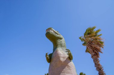 Cabazon, Kaliforniya, ABD: 6 Nisan 2019: Güney Kaliforniya çölündeki yol kenarı gösteriminde uzun bir Tyrannosaurus Rex heykeline bakmak.