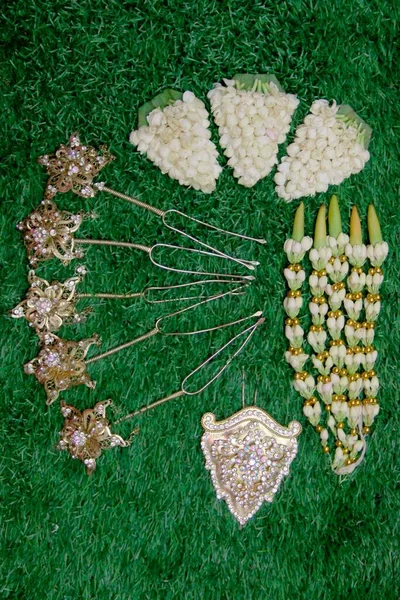 A picture of a combination of hairpin accessories and a brooch, which is silvery white and decorated with imitation pearl diamonds, and a picture of a strand of white jasmine.