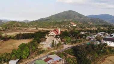 Pirinç tarlalarının ve arka planda dağ olan köyün havadan görünüşü