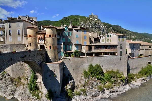 Entrevaux, Provence, Fransa. Var nehri üzerinde köprüsü olan küçük romantik bir köy. Arka planda mavi gökyüzü olan köy manzarası.