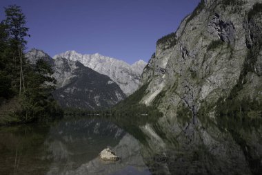 View of Obersee in Schnau am Knigssee. Reflection of the mountains in the water. Germany, Europe. clipart