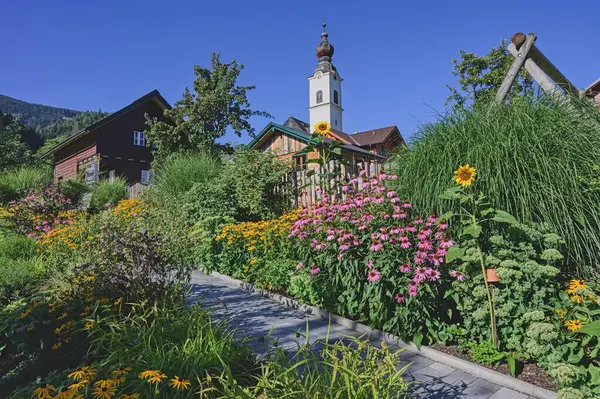 stock image View of small street with blooming flowers in Haus im Ennstal. Austria, Europe.