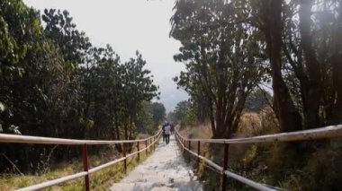 İnsanlar doğada Ghorepani patikasının etrafındaki patikadan aşağı iniyorlar.