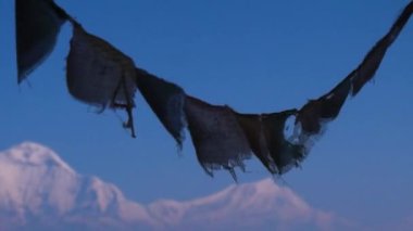 Prayer flags with mountain and blue sky in the background located in Nepal.