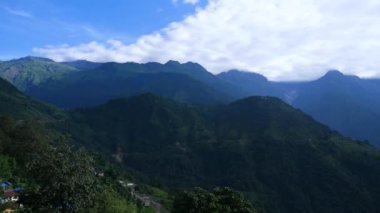Bu Nepal, Gandruk 'tan bir görüntü. Ormanlarla dolu yeşil tepeler, karlı dağlar ve zaman içinde bazı bulutlar..
