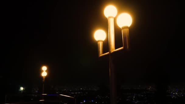 ポーランド人のランプは背景の夜の暗い都市と夜に輝きます — ストック動画