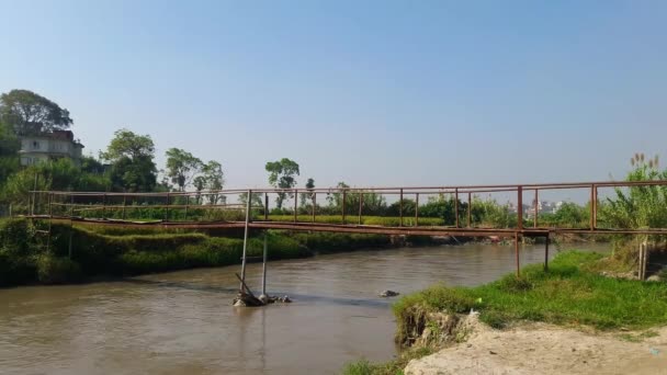 地元の人々によって作られた川の古い鉄の橋のタイムラプス 橋やカラスを渡る人 — ストック動画