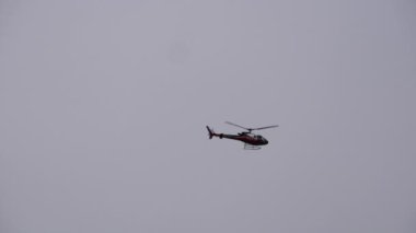 Katmandu, Nepal - 28 Ekim 2023: Katmandu semalarında uçan kırmızı ve beyaz renkli bir helikopter.