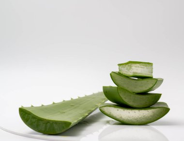 Aloe vera dilimlenmiş ve bir aloe vera yaprağı ile istiflenmiş..
