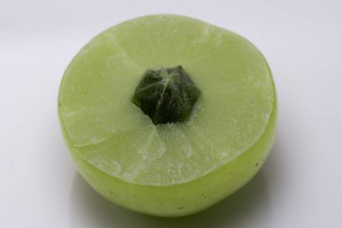 Beyaz arka planda Hint Bektaşi üzümü olarak da bilinen dilimlenmiş Amla 'nın Macro karesi..