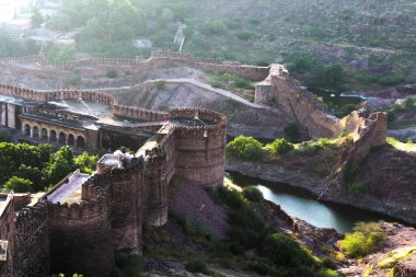 Dağlarla çevrili bir kalenin resmi..