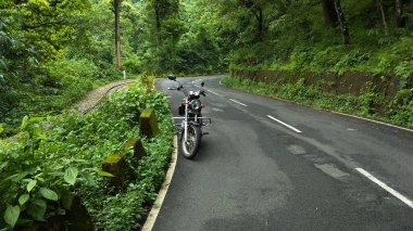 Yolun kenarına park edilmiş güzel dağ manzaralı ve yan tarafında tren yolu olan bir bisiklet..
