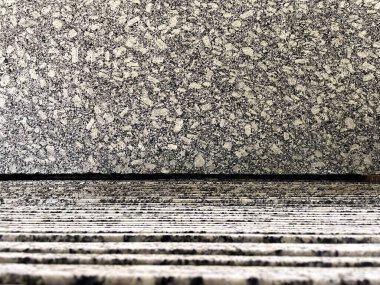 Granit bir fabrikada dikey istiflenmiş granit levhaların üzerinde sergilenen granit levhanın yakın çekim görüntüsü..