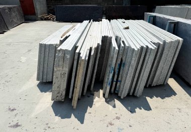 Bir fabrikada dikey olarak istiflenmiş granit levhaların yakın plan çekimi..