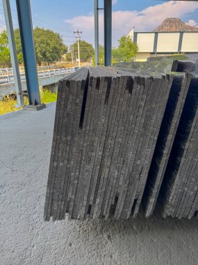 Bir fabrikada dikey olarak istiflenmiş granit levhaların yakın plan çekimi..