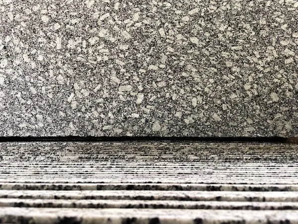 Granit bir fabrikada dikey istiflenmiş granit levhaların üzerinde sergilenen granit levhanın yakın çekim görüntüsü..