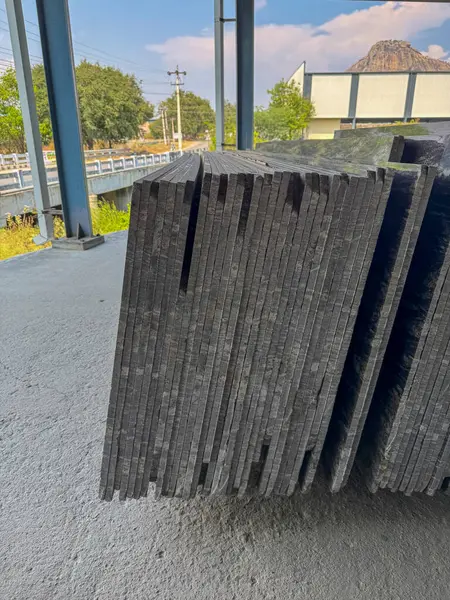 Bir fabrikada dikey olarak istiflenmiş granit levhaların yakın plan çekimi..