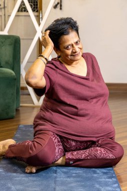 Yoga seansından sonra yoga minderinde poz veren bir bayanın yakın çekimi.