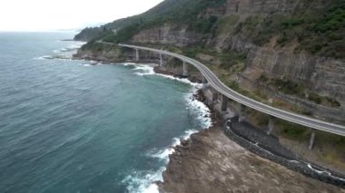 Pasifik kıyılarındaki Sea Cliff Köprüsü 'nün havadan görüntüsü Wollongong, Illawarra, Yeni Güney Galler, Avustralya. 665 metre uzunluğundaki Köprü, Büyük Pasifik Yolu boyunca önemli bir noktadır. Köprü Wollongong halkı ve dünya için bir ikondur..