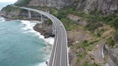 Pasifik kıyılarındaki Sea Cliff Köprüsü 'nün havadan görüntüsü Wollongong, Illawarra, Yeni Güney Galler, Avustralya. 665 metre uzunluğundaki Köprü, Büyük Pasifik Yolu boyunca önemli bir noktadır. Köprü Wollongong halkı ve dünya için bir ikondur..