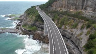 Pasifik kıyılarındaki Sea Cliff Köprüsü 'nün havadan görüntüsü Wollongong, Illawarra, Yeni Güney Galler, Avustralya. 665 metre uzunluğundaki Köprü, Büyük Pasifik Yolu boyunca önemli bir noktadır. Köprü Wollongong halkı ve dünya için bir ikondur..
