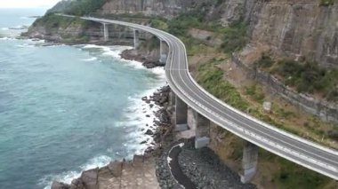 Pasifik kıyılarındaki Sea Cliff Köprüsü 'nün havadan görüntüsü Wollongong, Illawarra, Yeni Güney Galler, Avustralya. 665 metre uzunluğundaki Köprü, Büyük Pasifik Yolu boyunca önemli bir noktadır. Köprü Wollongong halkı ve dünya için bir ikondur..