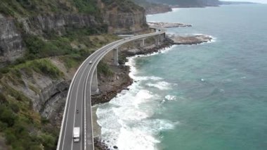 Pasifik kıyılarındaki Sea Cliff Köprüsü 'nün havadan görüntüsü Wollongong, Illawarra, Yeni Güney Galler, Avustralya. 665 metre uzunluğundaki Köprü, Büyük Pasifik Yolu boyunca önemli bir noktadır. Köprü Wollongong halkı ve dünya için bir ikondur..