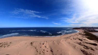 Newcastle Nobbys Plajı NSW Avustralya Sahil Sahili ve Okyanus Mavi Gök ve Yuvarlanan Dalgalar Altında