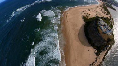 Newcastle Nobbys Plajı NSW Avustralya Sahil Sahili ve Okyanus Mavi Gök ve Yuvarlanan Dalgalar Altında