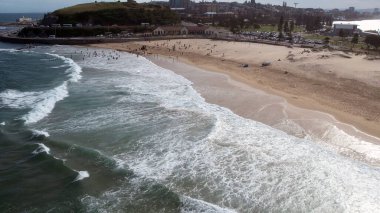 Newcastle Nobbys Plajı NSW Avustralya Sahil Sahili ve Okyanus Mavi Gök ve Yuvarlanan Dalgalar Altında