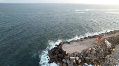 Newcastle, New South Wales, Avustralya. Dalgalar açık bir gökyüzünün altında derin mavi denize doğru uzanıyor. Huzurlu sahne okyanus dalgaları ve gökyüzünün renklerini gösteriyor..