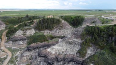 Horseshoe Canyon Alberta Canada Drumheller Engebeli Çorak Topraklar Arazisi Eroded Hills ve Vegetation, belirgin katmanlı katmanlar ve bulutlu gökyüzünün altında dağınık bitki örtüleri