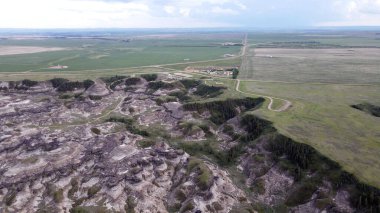 Horseshoe Canyon Alberta Canada Drumheller Engebeli Çorak Topraklar Arazisi Eroded Hills ve Vegetation, belirgin katmanlı katmanlar ve bulutlu gökyüzünün altında dağınık bitki örtüleri