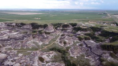 Horseshoe Canyon Alberta Canada Drumheller Engebeli Çorak Topraklar Arazisi Eroded Hills ve Vegetation, belirgin katmanlı katmanlar ve bulutlu gökyüzünün altında dağınık bitki örtüleri