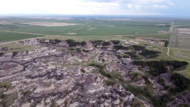 Horseshoe Canyon Alberta Canada Drumheller Engebeli Çorak Topraklar Arazisi Eroded Hills ve Vegetation, belirgin katmanlı katmanlar ve bulutlu gökyüzünün altında dağınık bitki örtüleri