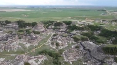 Baterist Alberta Kanada Engebeli Çorak Topraklar Hava Manzarası Eroded Hills ve Vegetation, farklı katmanlı tepeler aşınmış ve bulutlu gökyüzünün altında dağınık bitki örtüleri