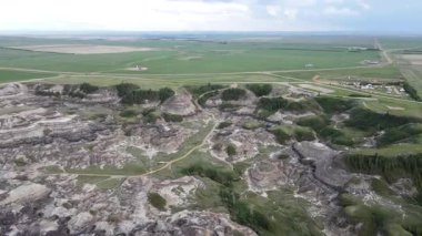 Baterist Alberta Kanada Engebeli Çorak Topraklar Hava Manzarası Eroded Hills ve Vegetation, farklı katmanlı tepeler aşınmış ve bulutlu gökyüzünün altında dağınık bitki örtüleri