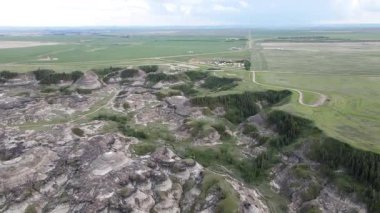 Baterist Alberta Kanada Engebeli Çorak Topraklar Hava Manzarası Eroded Hills ve Vegetation, farklı katmanlı tepeler aşınmış ve bulutlu gökyüzünün altında dağınık bitki örtüleri