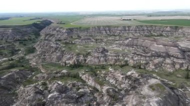 Baterist Alberta Kanada Engebeli Çorak Topraklar Hava Manzarası Eroded Hills ve Vegetation, farklı katmanlı tepeler aşınmış ve bulutlu gökyüzünün altında dağınık bitki örtüleri
