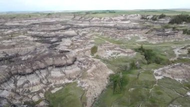 Baterist Alberta Kanada Engebeli Çorak Topraklar Hava Manzarası Eroded Hills ve Vegetation, farklı katmanlı tepeler aşınmış ve bulutlu gökyüzünün altında dağınık bitki örtüleri