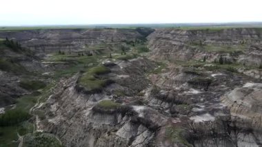 Baterist Alberta Kanada Engebeli Çorak Topraklar Hava Manzarası Eroded Hills ve Vegetation, farklı katmanlı tepeler aşınmış ve bulutlu gökyüzünün altında dağınık bitki örtüleri