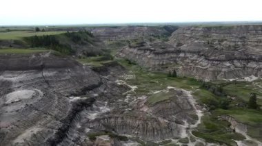Baterist Alberta Kanada Engebeli Çorak Topraklar Hava Manzarası Eroded Hills ve Vegetation, farklı katmanlı tepeler aşınmış ve bulutlu gökyüzünün altında dağınık bitki örtüleri