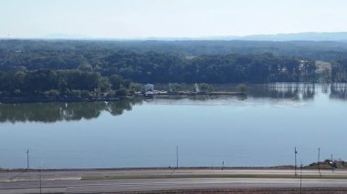 Coosa Nehri 'nin üzerindeki köprüden, 759 nolu karayolu ve 411 nolu otoban, bereketli orman ve Berrak Gök Altındaki uzak tepe manzarası. Sakin su mavi gökyüzünü yansıtır ve manzaralı bir manzara yaratır..