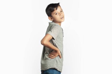 Sırtı beyaz arka planda gerilen Hintli çocuk sırt ağrısı çekiyor.