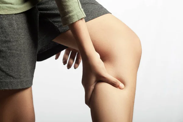 woman\'s calf muscle cramped, holding leg muscle pain