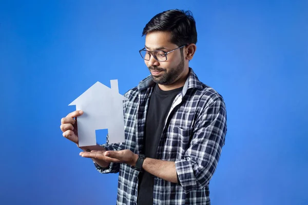 Mortgage loan, paper cutting, home insurance. Man holding house model.
