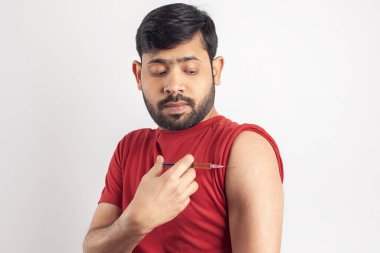 Bekar bir adam omzuna aşı şırıngası enjekte ediyor.
