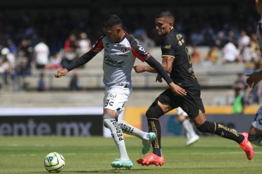 5 Şubat 2023 'te Mexico City, Meksika' da Pumas 'lı Higor Meritao ve Atlas' lı Christopher Trejo, 2023 Olimpiyat Üniversite Stadyumu 'nda oynanan kapanış maçında top için mücadele ettiler.