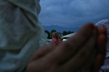 16 Temmuz 2023, Srinagar Kashmir, Hindistan: Bir Kaşmir Müslüman kadını, başrahibin peygamberin sakalından olduğuna inanılan bir kalıntı sergilemesini beklerken dua ediyor (PBUH))