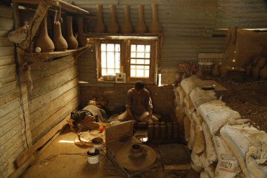 10 Ağustos 2023, Srinagar Kashmir, Hindistan: Kaşmirli bir çömlekçi olan Mohammad Yousuf Kumar, Srinagar 'ın eteklerindeki atölyesinde topraktan Tumbaknari (bir Kashmiri müzik davulu) yapmak için taze çamur hazırlıyor. Kaşmir düğünlerinde